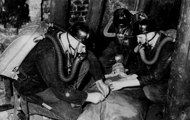 Grubenwehrmitglieder bei praktischer Ausbildung auf Übungsstrecke um 1965