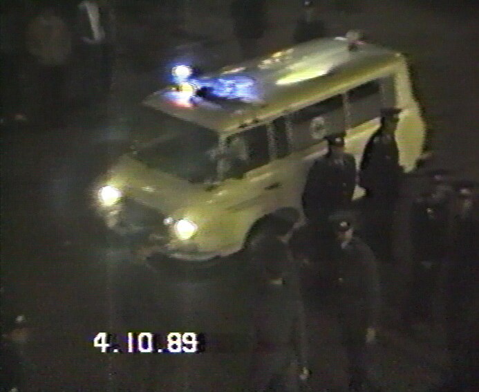 Volkspolizisten vor Polizeiwagen bei Nacht